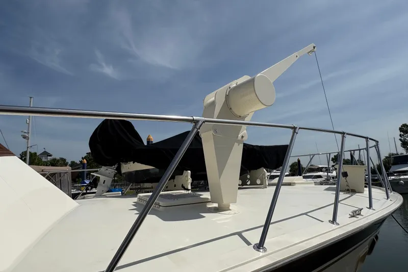 Slide: The Image of 1985 Hatteras 60 Convertible yacht deck with railing and equipment under clear sky. - 24