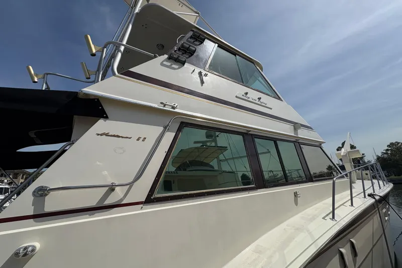 Slide: The Image of 1985 Hatteras 60 Convertible yacht docked under clear sky. - 25