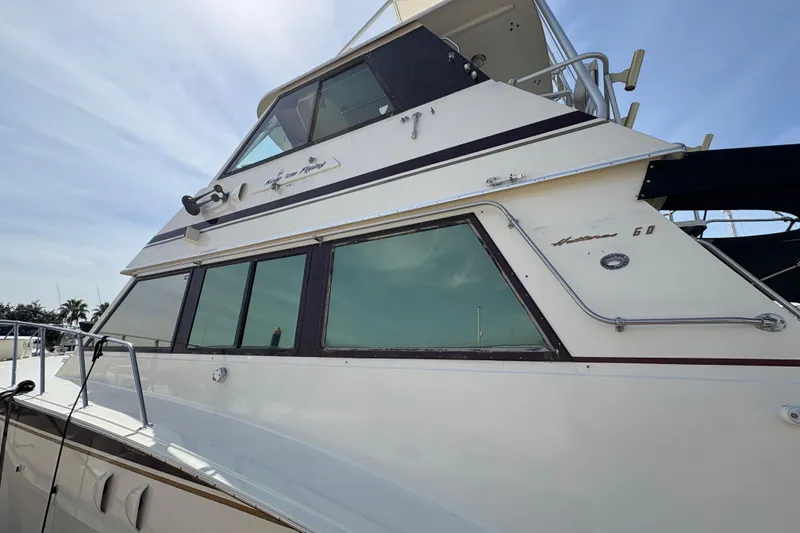 Slide: The Image of 1985 Hatteras 60 Convertible yacht with sleek design and large windows. - 28