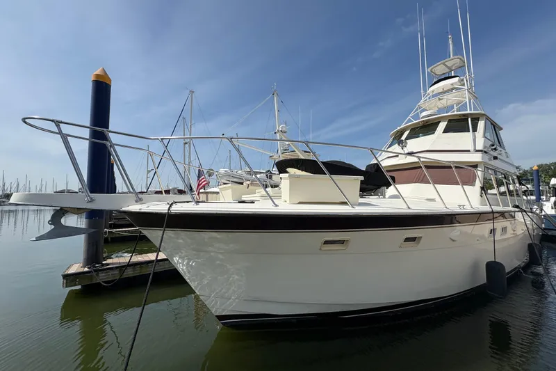Slide: The Image of 1985 Hatteras 60 Convertible yacht docked at marina under clear blue sky. - 29