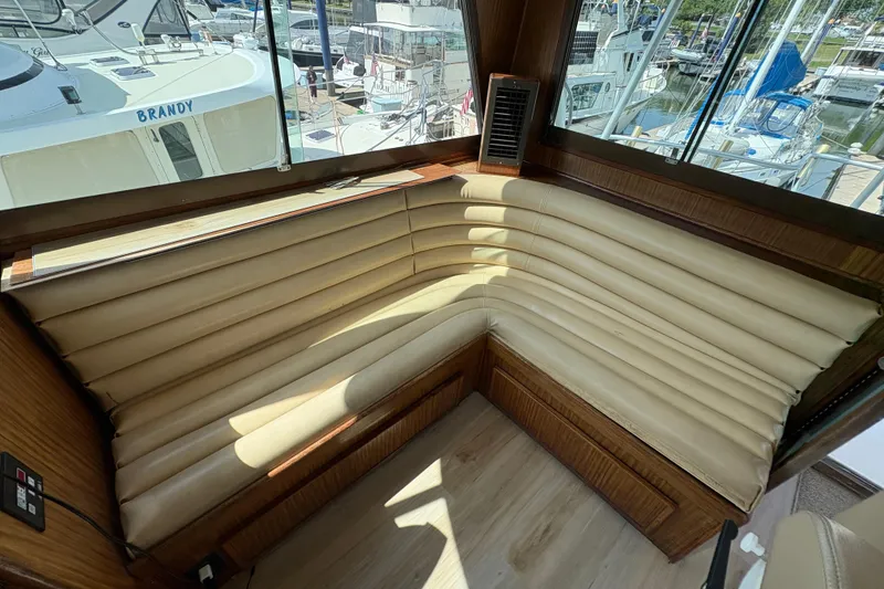 Slide: The Image of Interior seating area of a 1985 Hatteras 60 Convertible yacht, featuring beige leather upholstery. - 40