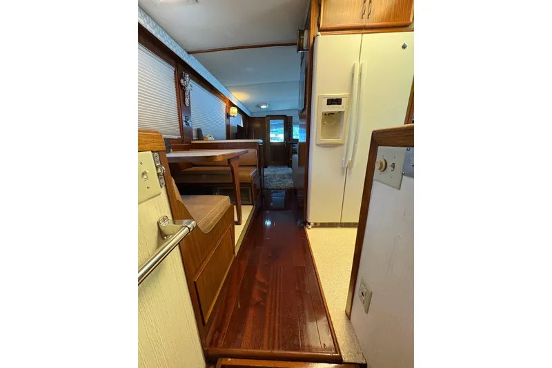 Slide: The Image of Interior view of 1985 Hatteras 60 Convertible yacht, featuring wood flooring and dining area. - 42