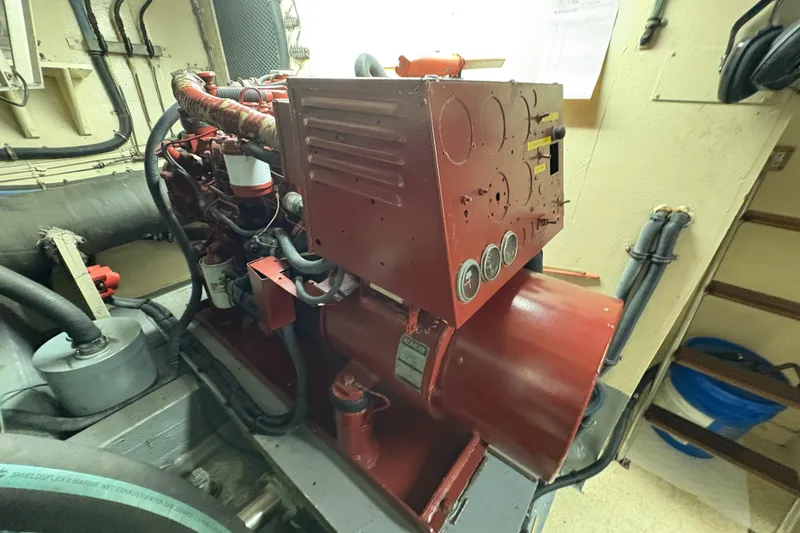 Slide: The Image of Engine room of a 1985 Hatteras 60 Convertible yacht, featuring red machinery and gauges. - 51