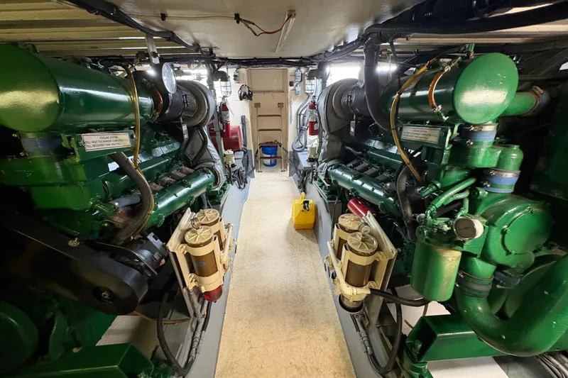Slide: The Image of Engine room of a 1985 Hatteras 60 Convertible yacht, showcasing dual green engines. - 52