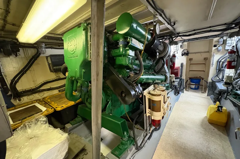 Slide: The Image of Engine room of a 1985 Hatteras 60 Convertible yacht, showcasing machinery and equipment. - 54