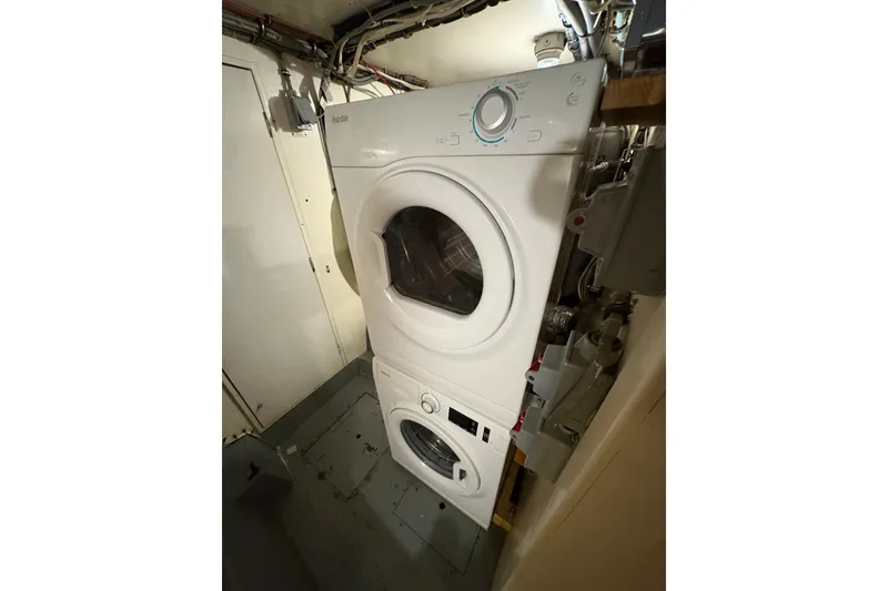 Slide: The Image of Stacked washer and dryer inside 1985 Hatteras 60 Convertible yacht laundry area. - 57