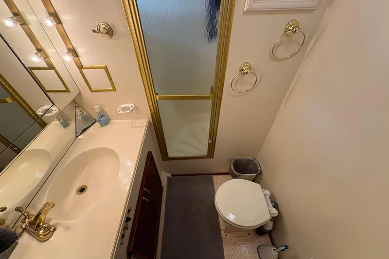 Slide: The Image of Bathroom interior of 1985 Hatteras 60 Convertible yacht with gold accents and shower. - 62