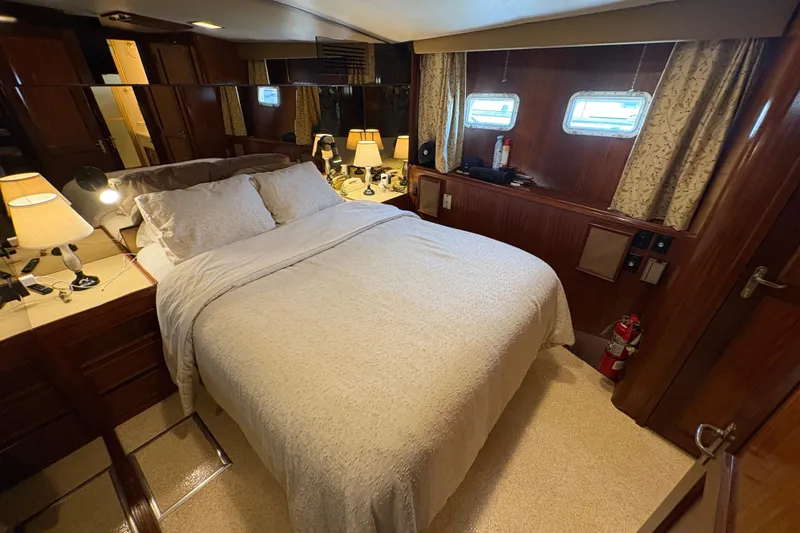 Slide: The Image of Luxurious bedroom interior of 1985 Hatteras 60 Convertible yacht with cozy bedding and elegant decor. - 64