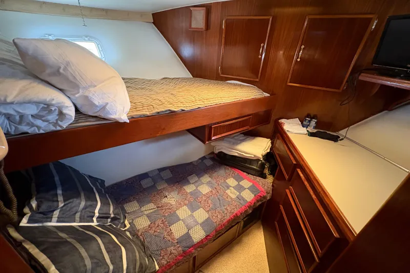 Slide: The Image of Cozy cabin interior of 1985 Hatteras 60 Convertible with bunk beds and wooden cabinetry. - 70