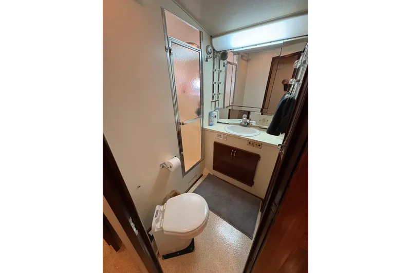 Slide: The Image of Bathroom interior of 1985 Hatteras 60 Convertible yacht, featuring sink, toilet, and shower. - 71