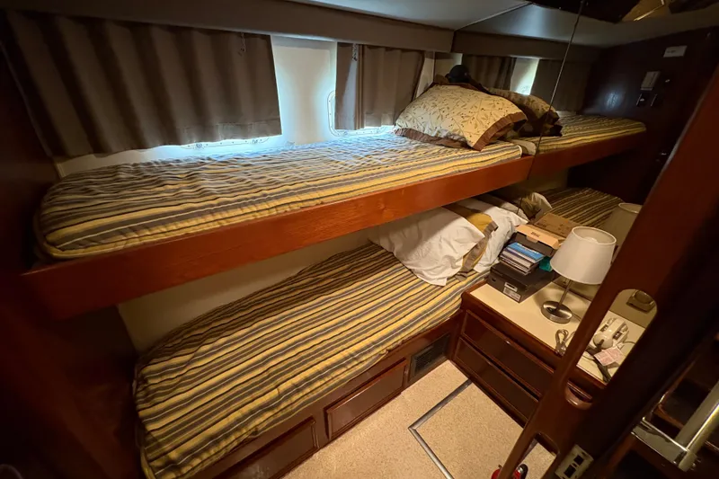 Slide: The Image of Bunk beds in 1985 Hatteras 60 Convertible yacht cabin with striped bedding and wooden accents. - 72
