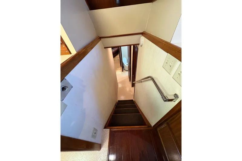Slide: The Image of Interior staircase of 1985 Hatteras 60 Convertible yacht, featuring wooden steps and handrail. - 73