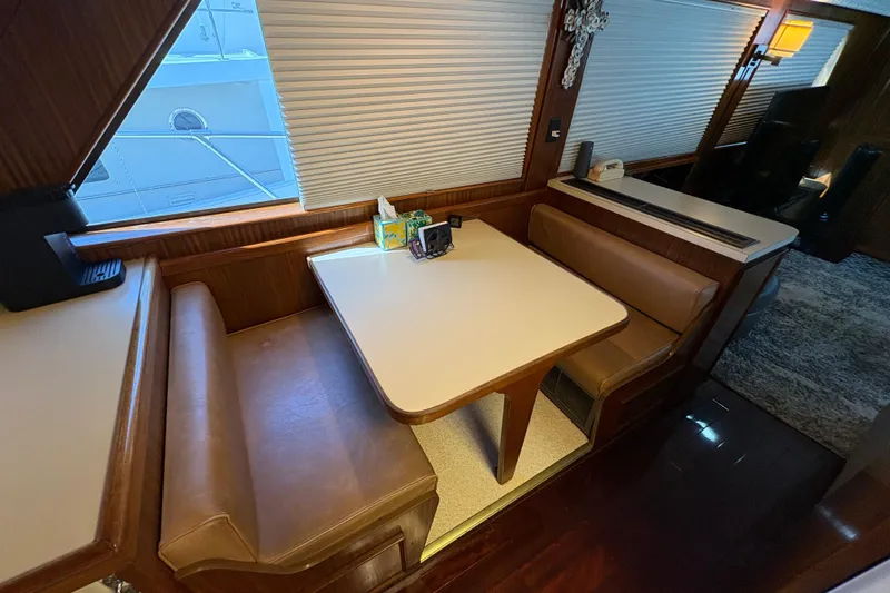 Slide: The Image of 1985 Hatteras 60 Convertible yacht interior with dining area and leather seating. - 74