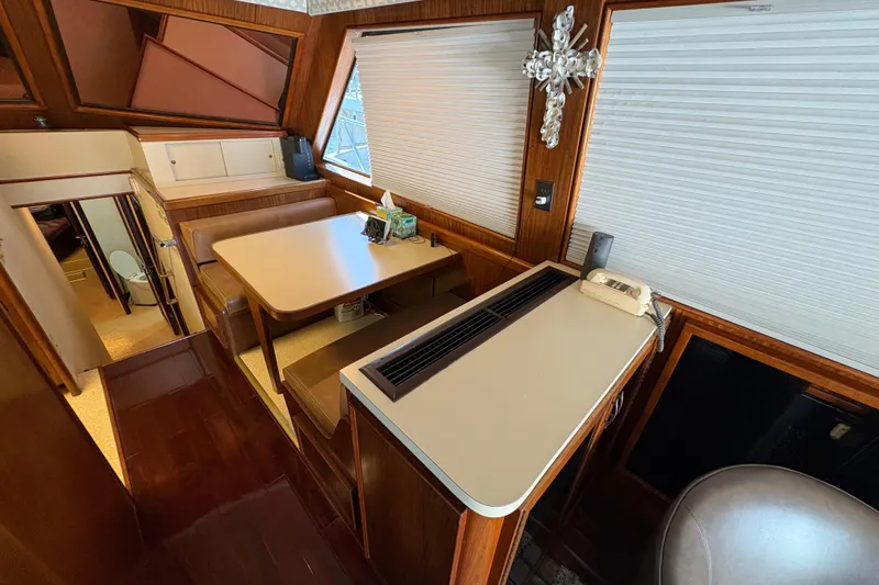 Slide: The Image of Interior of 1985 Hatteras 60 Convertible yacht with dining area and vintage decor. - 80