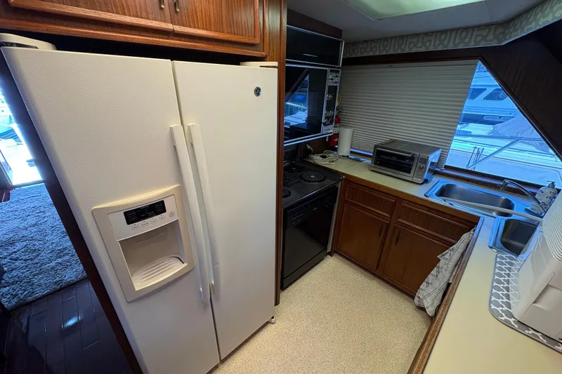 Slide: The Image of Kitchen area of 1985 Hatteras 60 Convertible yacht with appliances and wooden cabinetry. - 81