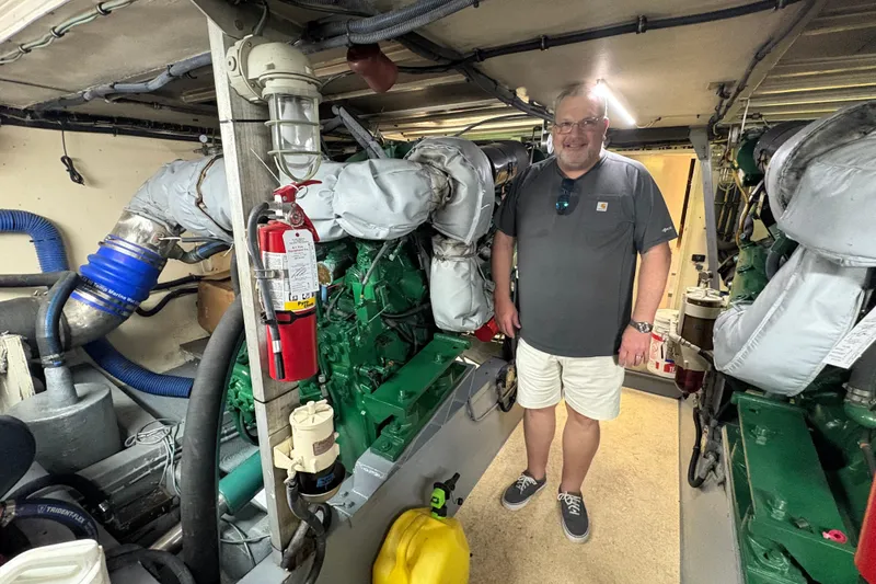 Slide: The Image of Man standing in engine room of 1985 Hatteras 60 Convertible yacht. - 85