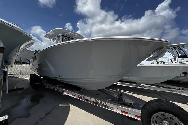 The Image of 2026 Sportsman Heritage 261 Center Console boat on trailer under blue sky. - 1