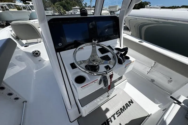 Slide: The Image of 2026 Sportsman Heritage 261 Center Console boat interior with steering wheel and controls. - 13