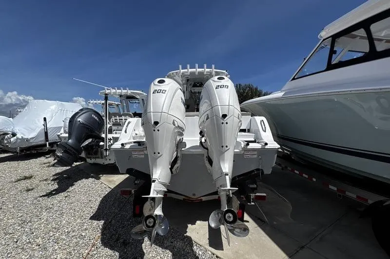 Slide: The Image of 2026 Sportsman Heritage 261 Center Console with dual 200 horsepower engines, docked outdoors. - 26