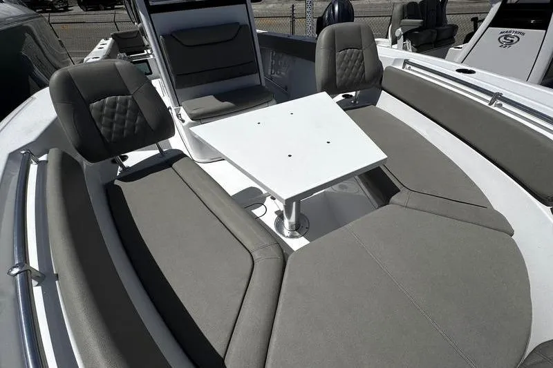 Slide: The Image of 2026 Sportsman Heritage 261 Center Console boat interior with cushioned seating and table. - 5