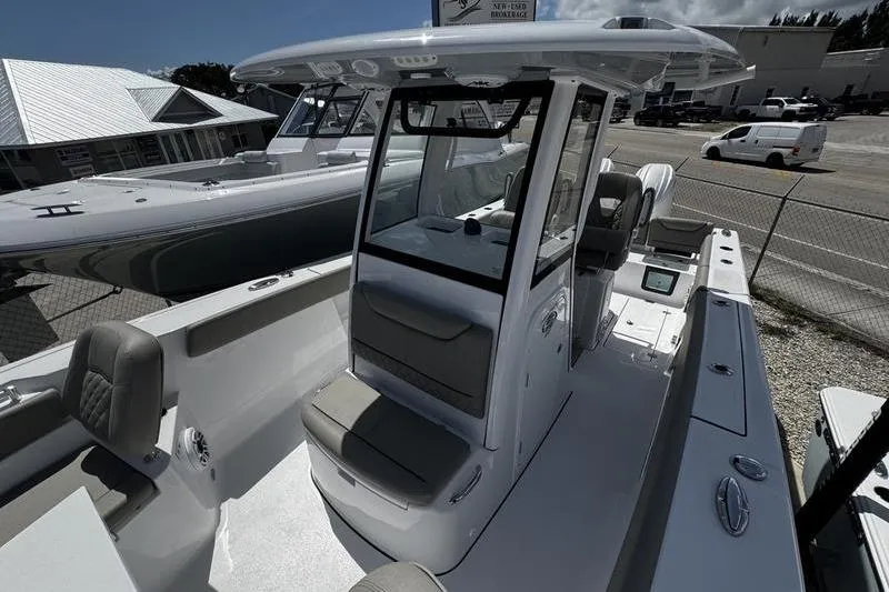 Slide: The Image of 2026 Sportsman Heritage 261 Center Console boat at a marina, showcasing sleek design and seating. - 8