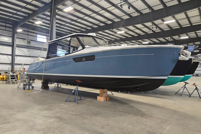 The Image of 2026 MJM 3 boat in a warehouse, elevated on stands for maintenance. - 0