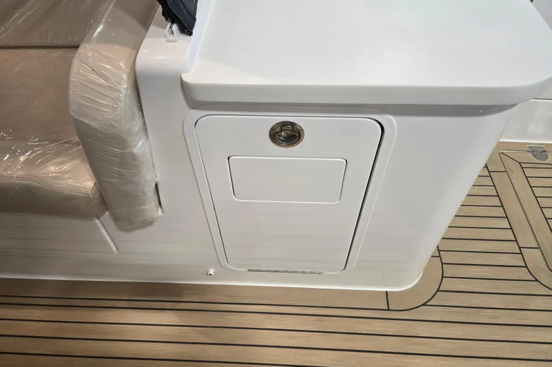 Slide: The Image of 2026 MJM 3 boat interior with cushioned seating and storage compartment on teak deck. - 10