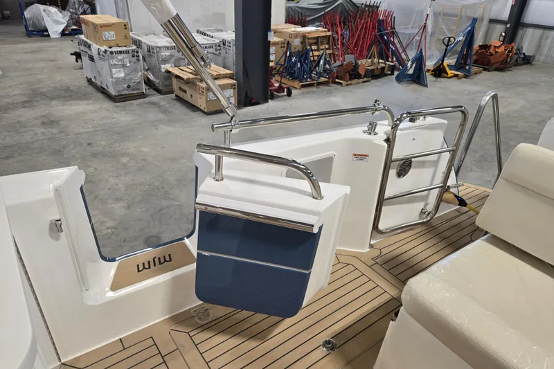 Slide: The Image of 2026 MJM 3 boat interior with teak flooring and stainless steel railings in a warehouse. - 18