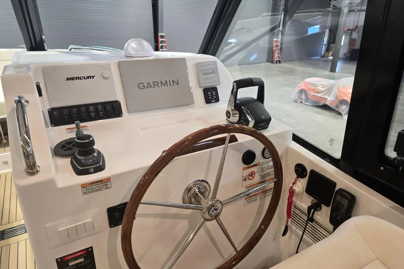 Slide: The Image of 2026 MJM 3 boat helm with Garmin and Mercury controls in a showroom. - 19