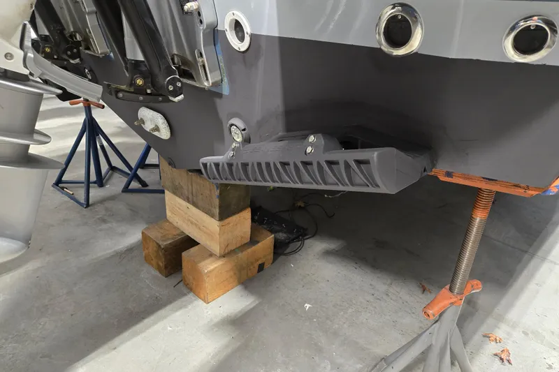 Slide: The Image of 2026 MJM 3 boat hull on blocks in a workshop setting. - 28