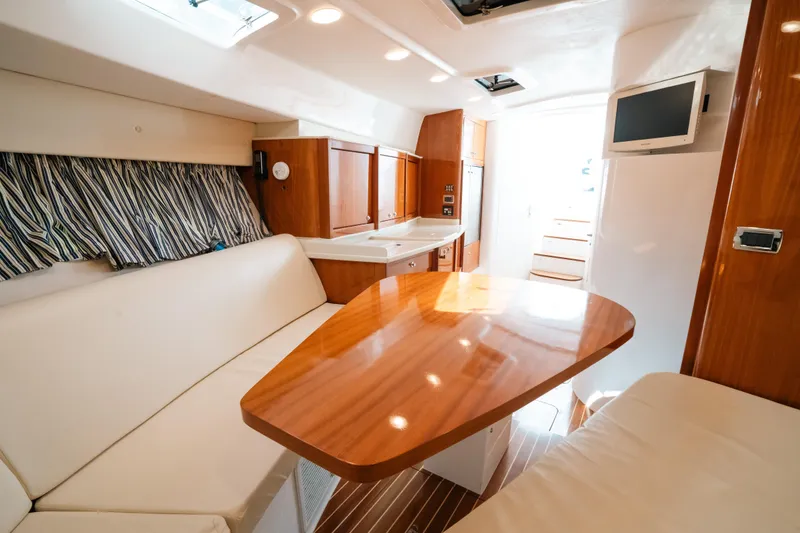 Slide: The Image of Luxurious interior of 2009 Intrepid 475 Sport Yacht with wood table and seating area. - 18