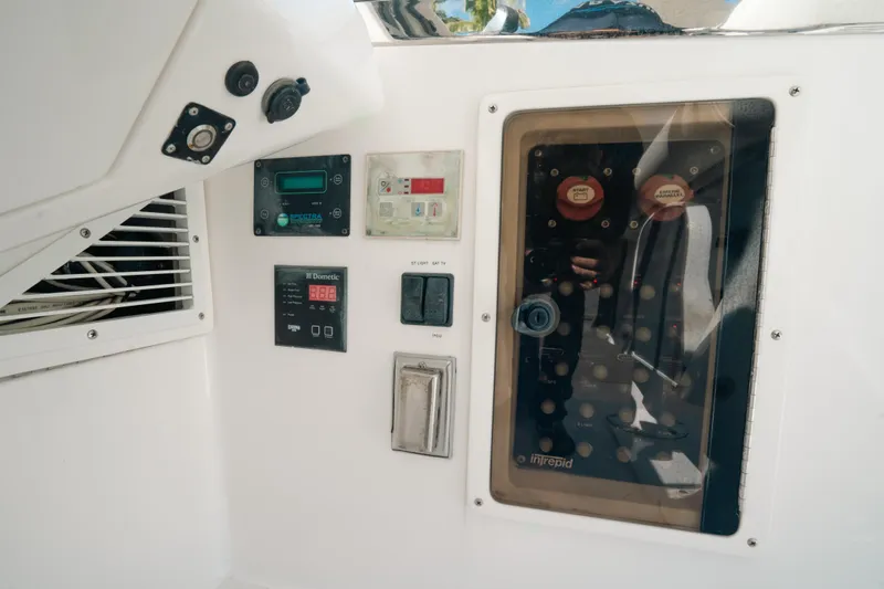 Slide: The Image of Control panel of a 2009 Intrepid 475 Sport Yacht, featuring various switches and displays. - 3