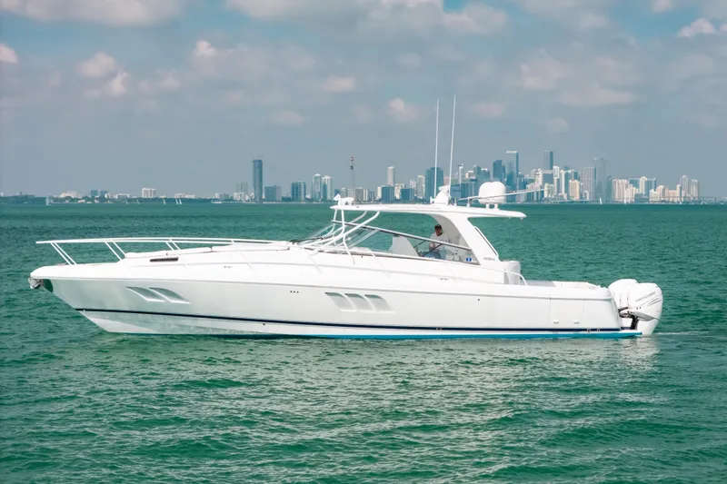Slide: The Image of 2009 Intrepid 475 Sport Yacht cruising on turquoise waters with city skyline backdrop. - 47