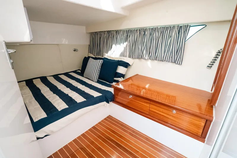 Slide: The Image of Luxurious cabin interior of 2009 Intrepid 475 Sport Yacht with striped bedding and wooden accents. - 5