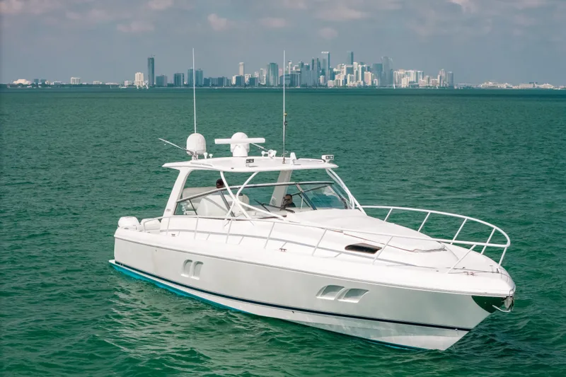 Slide: The Image of 2009 Intrepid 475 Sport Yacht cruising on turquoise waters with city skyline backdrop. - 50