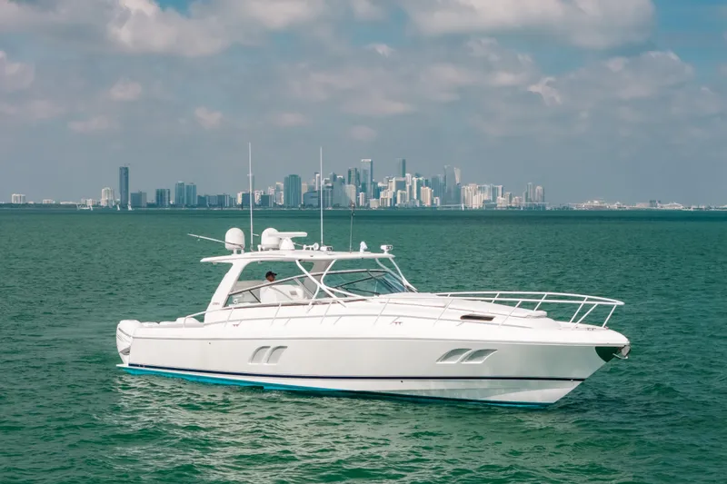 Slide: The Image of 2009 Intrepid 475 Sport Yacht cruising on turquoise waters with city skyline backdrop. - 51