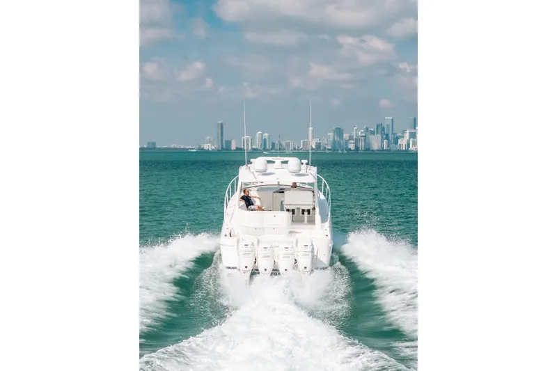 Slide: The Image of 2009 Intrepid 475 Sport Yacht cruising on open water with city skyline in background. - 53