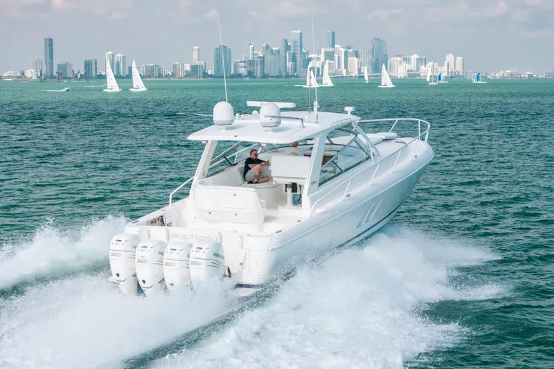 Slide: The Image of 2009 Intrepid 475 Sport Yacht cruising near city skyline with sailboats in background. - 56