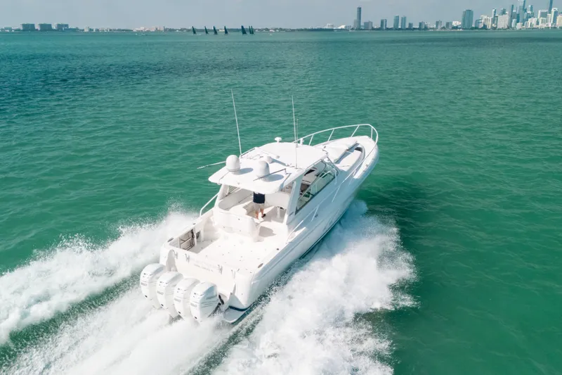 Slide: The Image of 2009 Intrepid 475 Sport Yacht cruising on turquoise waters near a city skyline. - 57