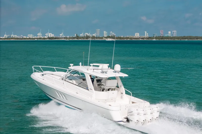 Slide: The Image of 2009 Intrepid 475 Sport Yacht cruising on turquoise waters near a city skyline. - 61