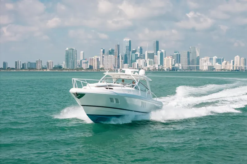 Slide: The Image of 2009 Intrepid 475 Sport Yacht cruising with city skyline backdrop. - 65