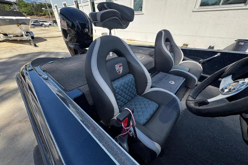 Slide: The Image of 2022 Triton 179 TrX boat interior with cushioned seats and steering wheel. - 4