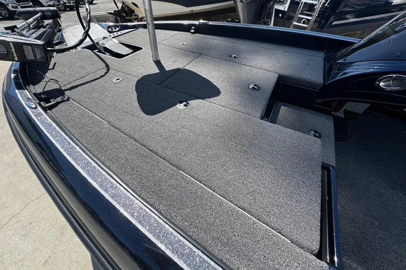 Slide: The Image of 2022 Triton 179 TrX boat deck with carpeted surface and storage compartments. - 9