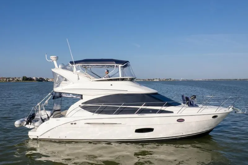 The Image of 2010 Meridian 391 Sedan yacht cruising on calm waters under clear blue sky. - 0