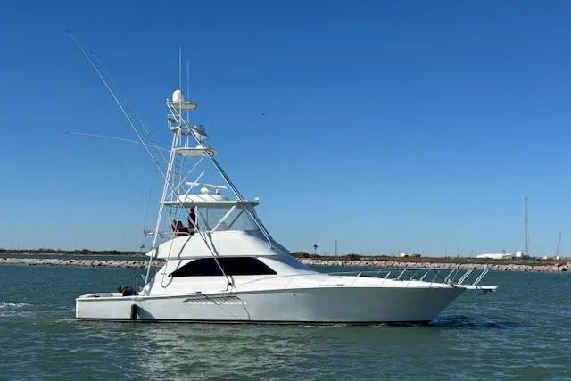 The Image of 2007 Viking 52 Convertible yacht cruising on calm waters under clear blue sky. - 0
