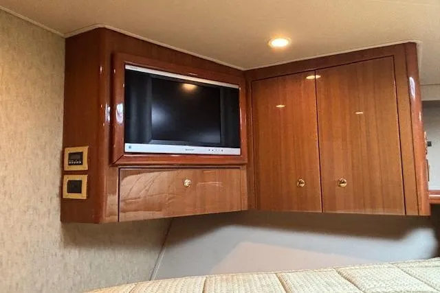Slide: The Image of Luxurious 2007 Viking 52 Convertible yacht interior with TV and wooden cabinets. - 33