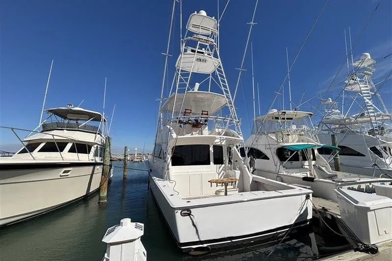 Slide: The Image of 2007 Viking 52 Convertible yacht docked at marina under clear blue sky. - 5
