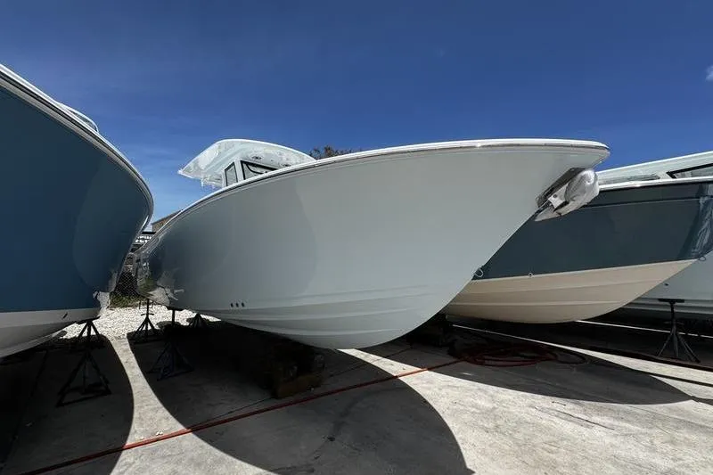 The Image of 2026 Sportsman Open 262 Center Console boat displayed outdoors under clear blue sky. - 1