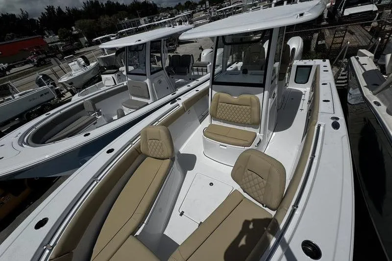Slide: The Image of 2026 Sportsman Open 262 Center Console boat with tan seating, docked in a marina. - 10