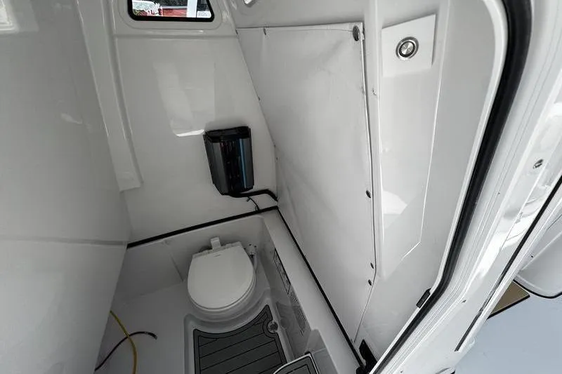 Slide: The Image of 2026 Sportsman Open 262 Center Console boat interior with compact marine toilet. - 17